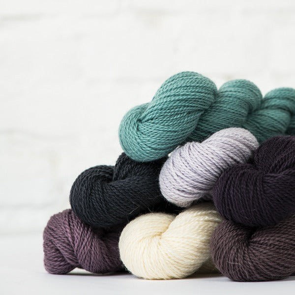 Neutral and cool tone skeins of Andorra merino wool and mohair blend sport weight yarn