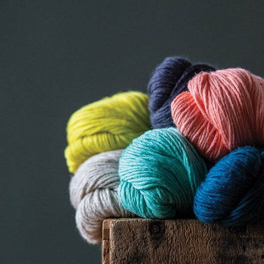 Kelbourne Woolens cotton linen blend Mojave yarn beauty shot on a rustic wood box with dark background